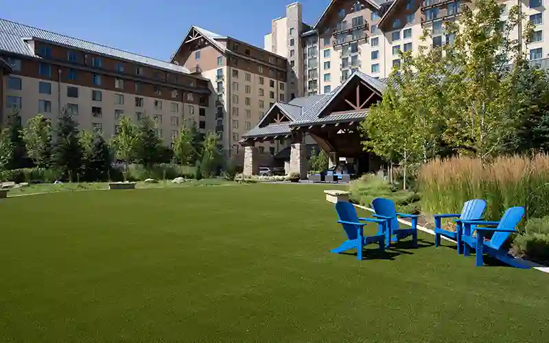 image of SYNLawn artificial grass at hotel resort with one group of blue lawn chairs