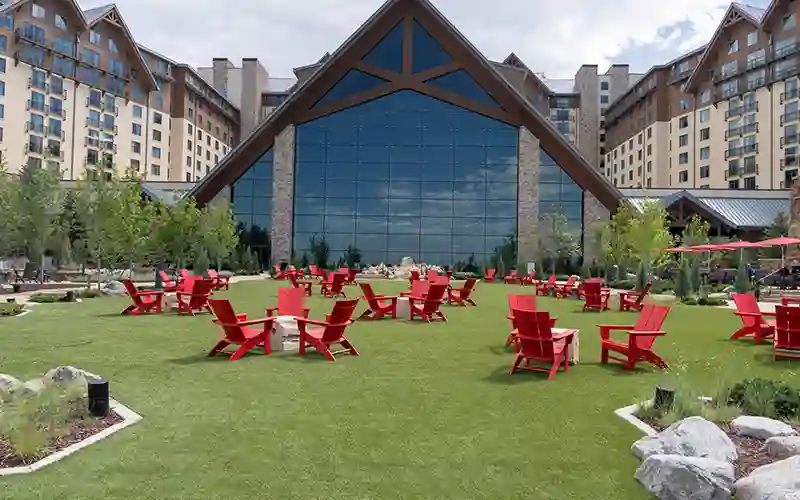 image of SYNLawn artificial grass at hotel resort with multiple groups of red lawn chairs